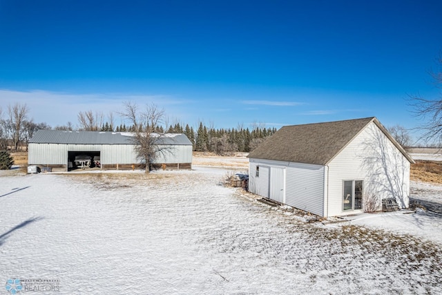 snow covered structure featuring a garage