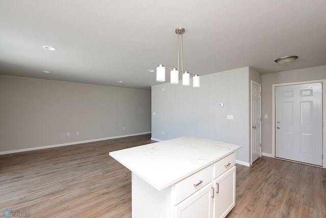 kitchen with white cabinetry, hanging light fixtures, light hardwood / wood-style floors, and a center island