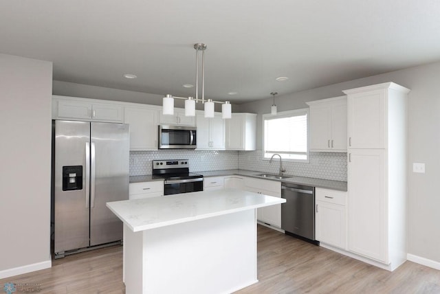 kitchen featuring white cabinetry, sink, hanging light fixtures, a center island, and stainless steel appliances