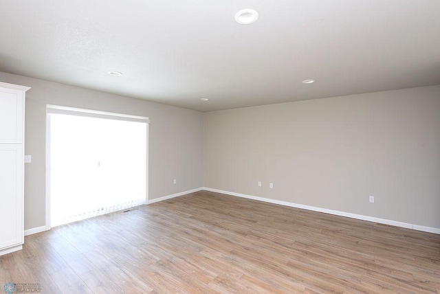 empty room with light hardwood / wood-style flooring