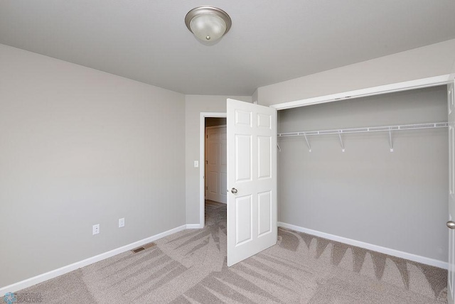 unfurnished bedroom with light carpet and a closet