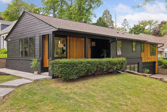 651 Sue Pl, Saint Paul, MN 55116 - view of front facade featuring a front yard, a garage, roof with shingles, and board and batten siding