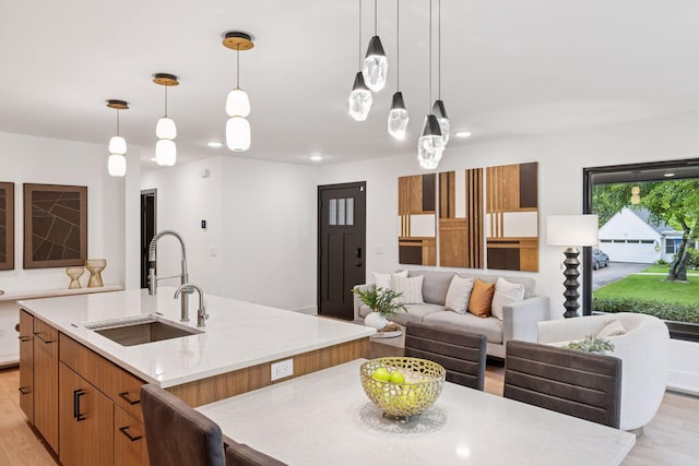 651 Sue Pl, Saint Paul, MN 55116 - kitchen with a sink, a kitchen island with sink, light wood-style flooring, hanging light fixtures, and recessed lighting