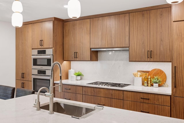 651 Sue Pl, Saint Paul, MN 55116 - kitchen with a sink, stainless steel double oven, decorative backsplash, gas cooktop, and pendant lighting