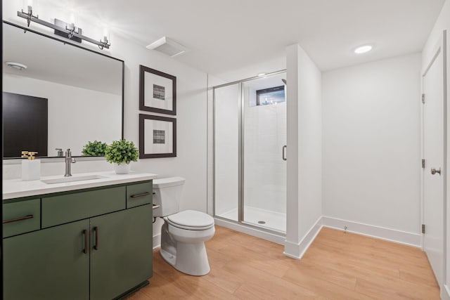 651 Sue Pl, Saint Paul, MN 55116 - bathroom with wood finished floors, vanity, toilet, a shower stall, and baseboards