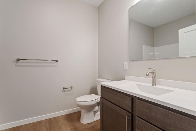 bathroom featuring hardwood / wood-style flooring, vanity, a shower, and toilet