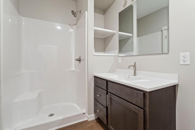 bathroom featuring walk in shower, vanity, and hardwood / wood-style flooring