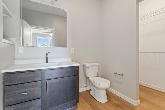 bathroom featuring ceiling fan, vanity, toilet, and hardwood / wood-style floors