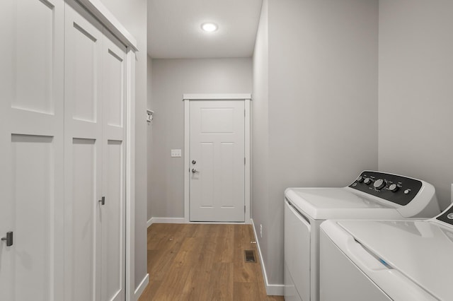 laundry room featuring light hardwood / wood-style floors and washing machine and dryer