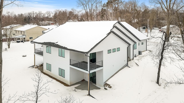 snow covered property with a balcony