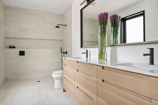 bathroom featuring vanity, toilet, and a tile shower