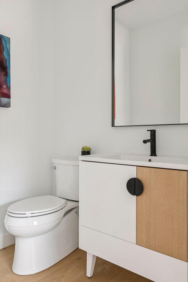 bathroom with vanity, hardwood / wood-style floors, and toilet