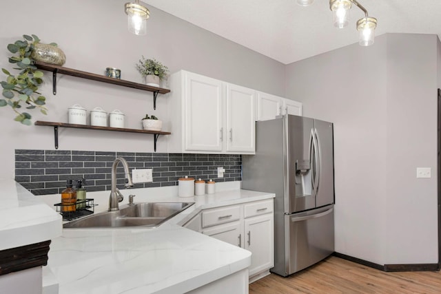 kitchen with open shelves, white cabinets, a sink, and stainless steel fridge with ice dispenser