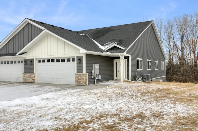 view of front of property with a garage and central air condition unit