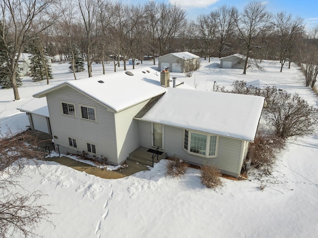 snowy aerial view featuring a garage