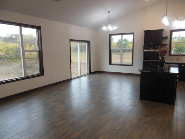 unfurnished living room featuring lofted ceiling, sink, and plenty of natural light