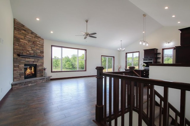 living room with ceiling fan, a stone fireplace, high vaulted ceiling, and dark hardwood / wood-style flooring