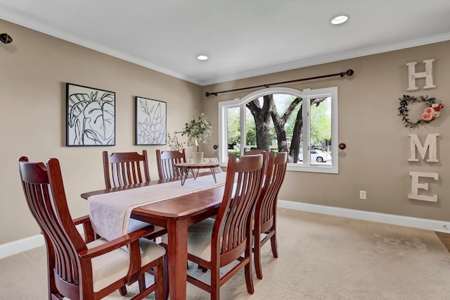 dining room with light carpet, baseboards, and crown molding