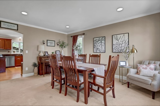 dining space featuring ornamental molding, arched walkways, a wealth of natural light, and baseboards