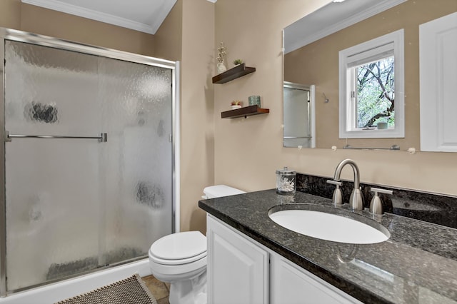 bathroom featuring toilet, ornamental molding, a shower stall, and vanity