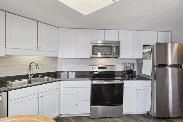 kitchen with dark wood-type flooring, stainless steel appliances, sink, and white cabinets