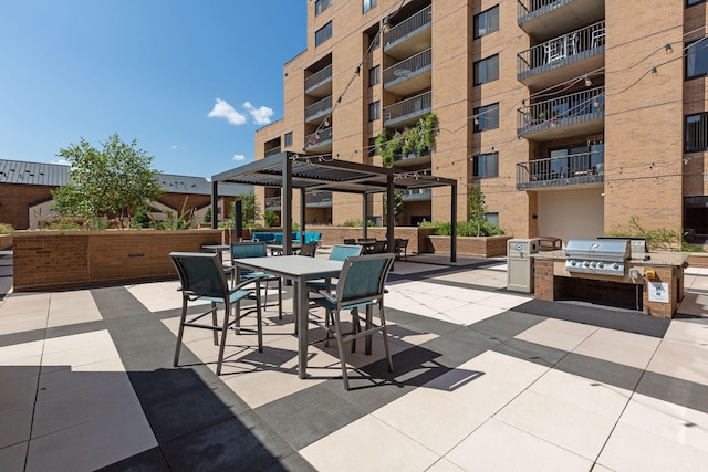 view of patio / terrace with area for grilling, a pergola, and exterior kitchen