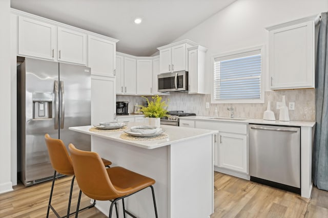 kitchen with white cabinetry, stainless steel appliances, tasteful backsplash, and sink