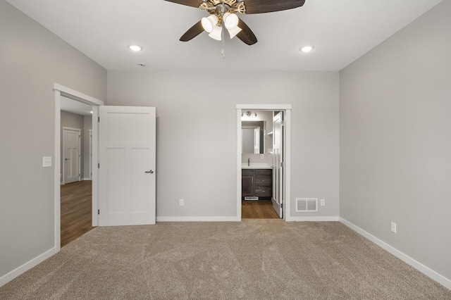 unfurnished bedroom featuring connected bathroom, sink, ceiling fan, and carpet