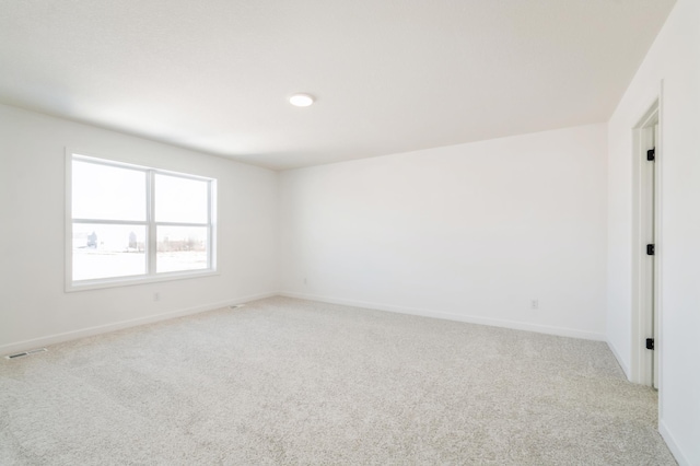 unfurnished room featuring light carpet