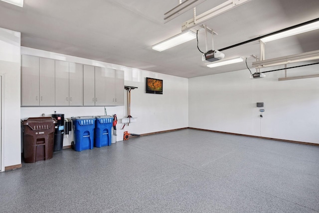 garage with baseboards and a garage door opener