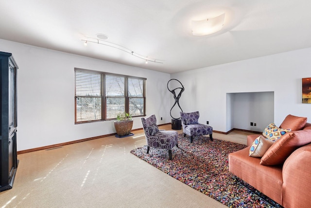 carpeted living room featuring baseboards and track lighting