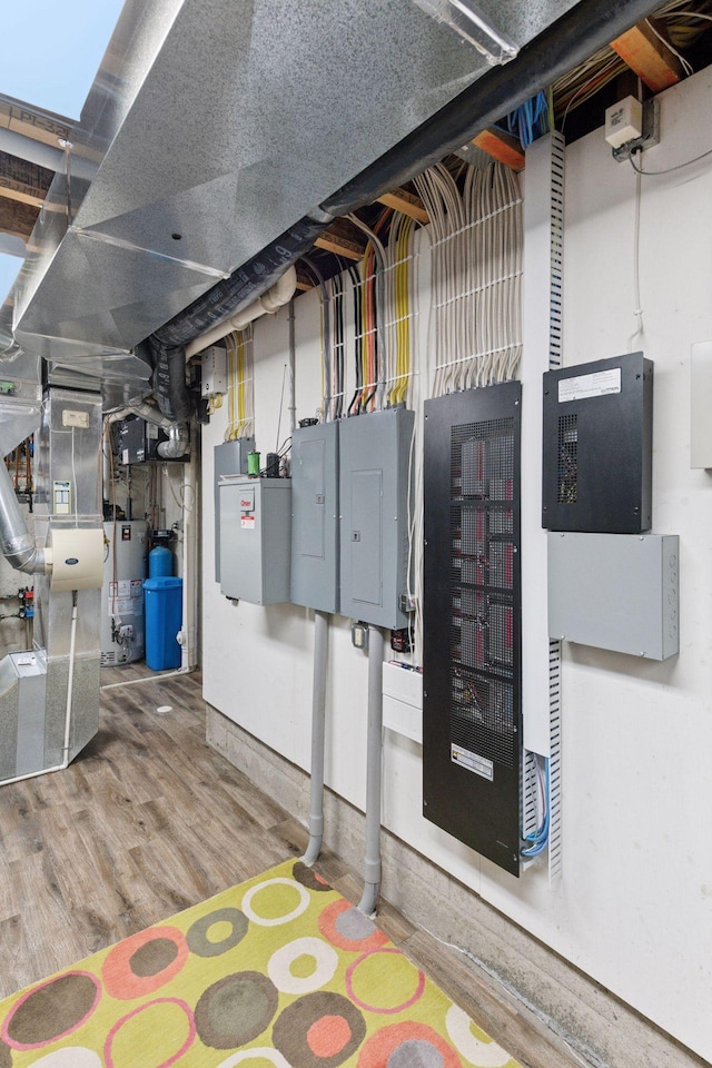 utility room with gas water heater, electric panel, and heating unit