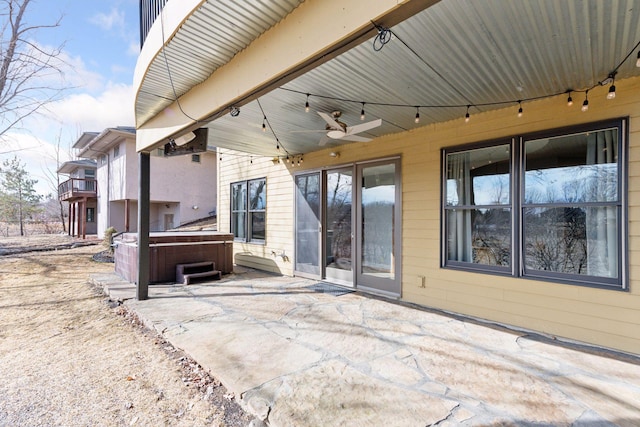 view of patio with ceiling fan and a hot tub