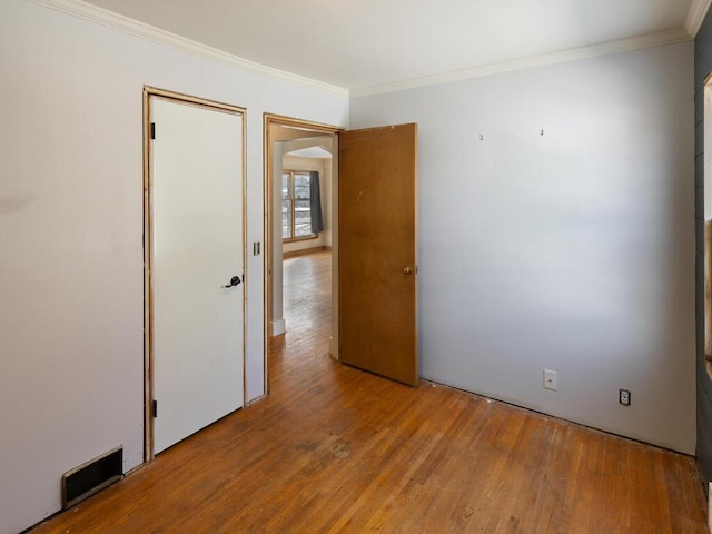 spare room featuring light hardwood / wood-style flooring and ornamental molding