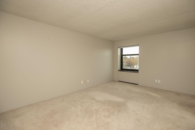 carpeted empty room featuring a textured ceiling