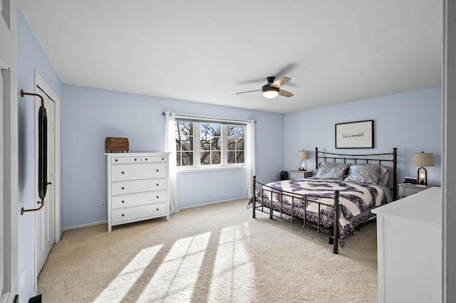 bedroom featuring light carpet, ceiling fan, and baseboards