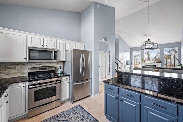 kitchen featuring appliances with stainless steel finishes, white cabinets, decorative backsplash, and high vaulted ceiling