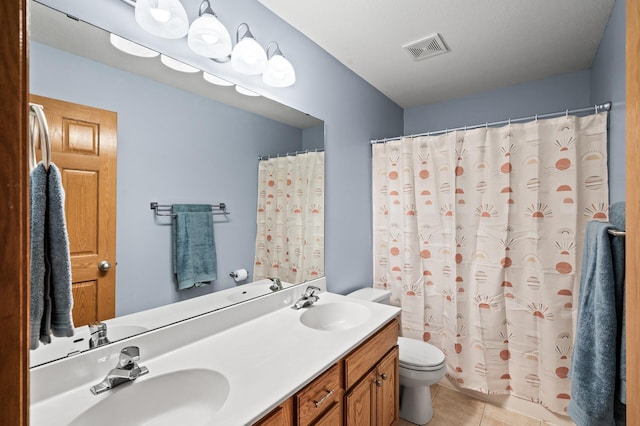 bathroom with toilet, visible vents, a sink, and tile patterned flooring