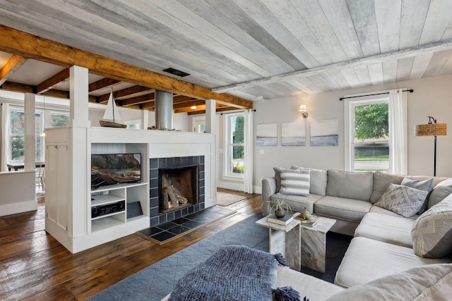 living room featuring a tiled fireplace, wood ceiling, beam ceiling, and dark wood-type flooring