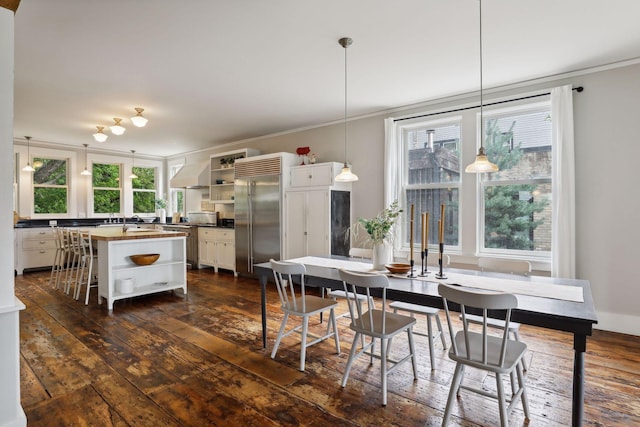 dining area featuring sink, crown molding, and dark hardwood / wood-style floors