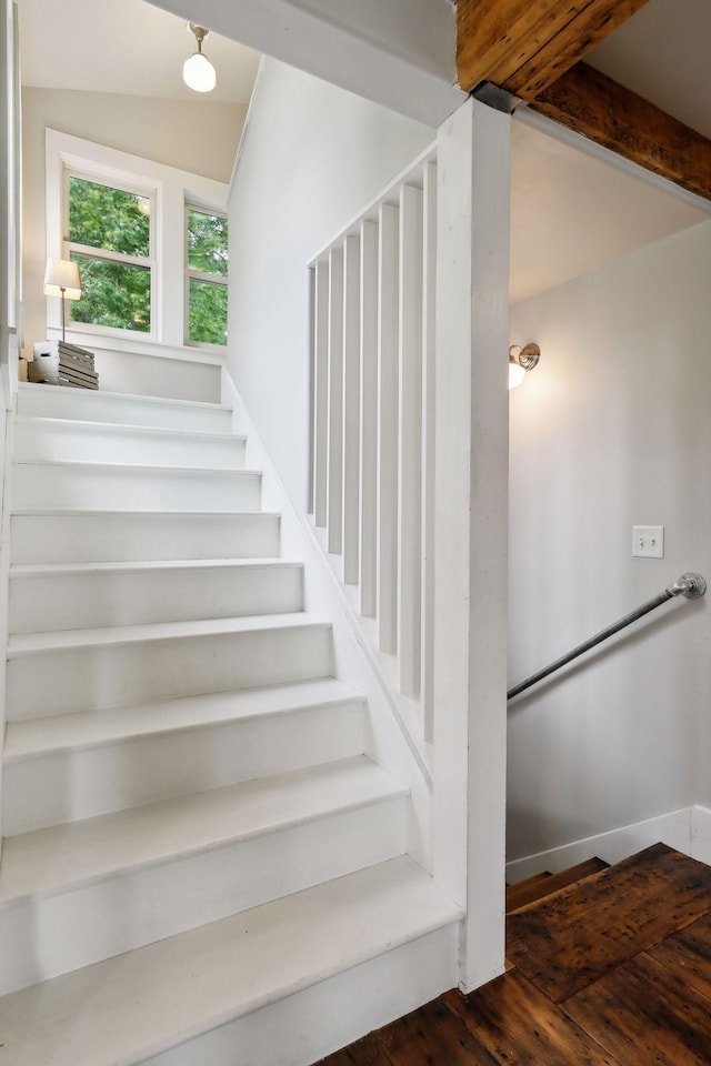 stairs featuring hardwood / wood-style flooring and lofted ceiling