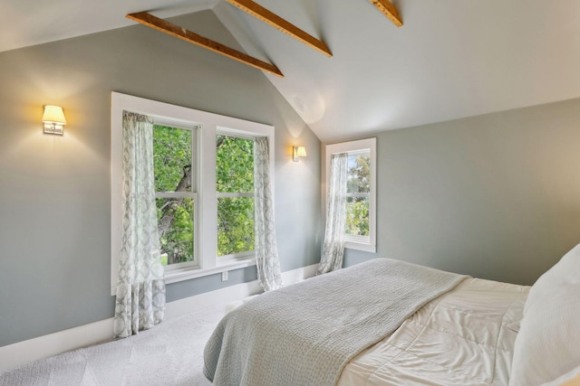 carpeted bedroom with vaulted ceiling with beams