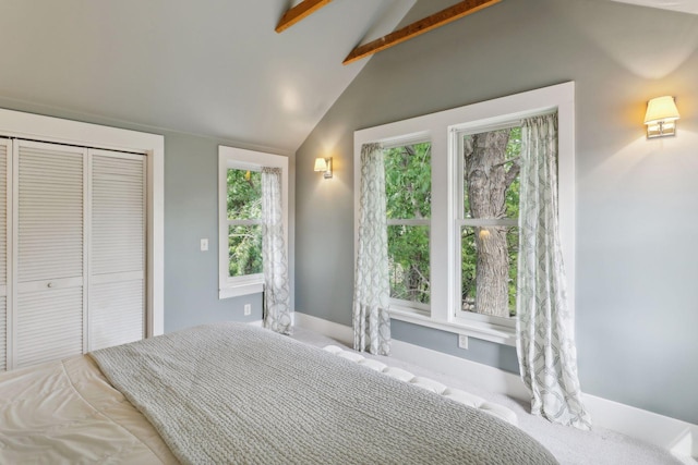 bedroom with a closet and vaulted ceiling with beams