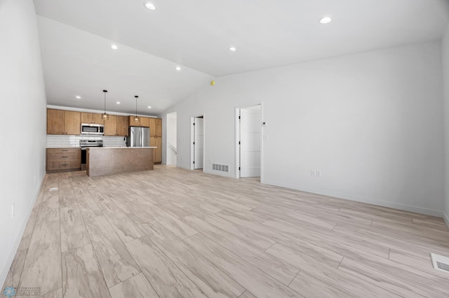 unfurnished living room featuring light wood-style flooring, visible vents, vaulted ceiling, and recessed lighting