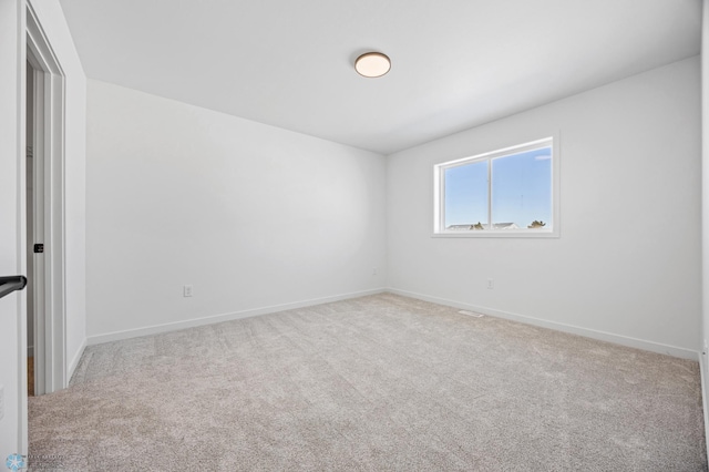 empty room with baseboards and light colored carpet