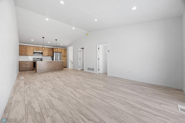 69 Cedar Dr, Mapleton, ND 58059 - unfurnished living room featuring vaulted ceiling, recessed lighting, light wood finished floors, and baseboards