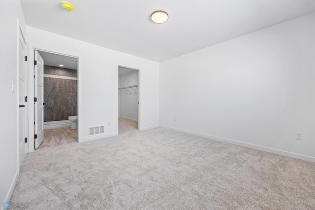 69 Cedar Dr, Mapleton, ND 58059 - unfurnished bedroom featuring carpet, a spacious closet, connected bathroom, baseboards, and a closet