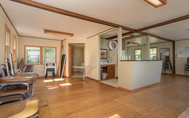 living area featuring a wealth of natural light, beamed ceiling, and baseboards