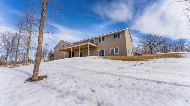 snow covered property featuring a garage and a wooden deck