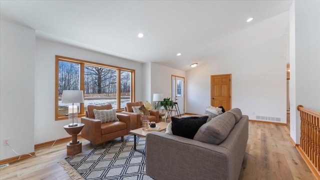 living room featuring lofted ceiling, recessed lighting, visible vents, baseboards, and light wood-type flooring